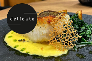 Elegant angerichtetes Fischgericht mit Logo namens Delicato